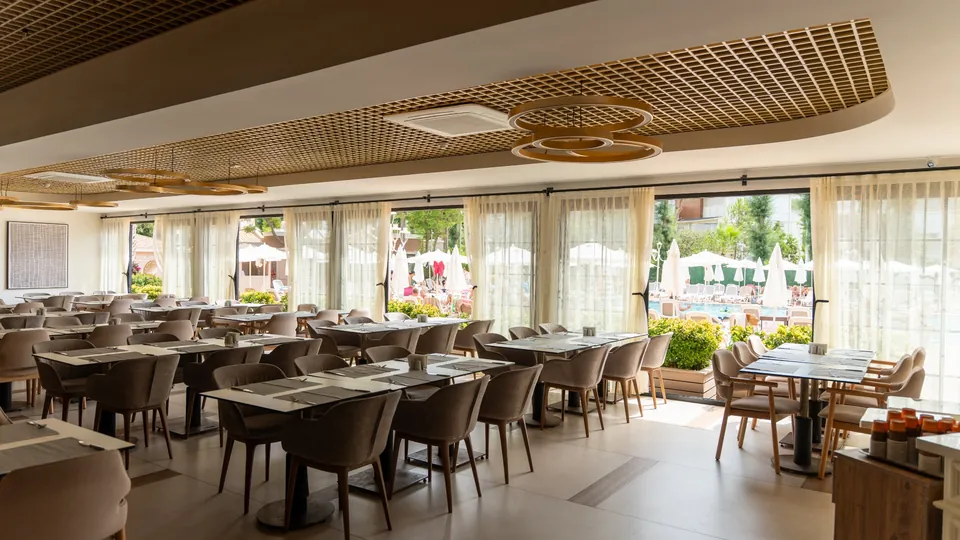Geniş camlar boyunca tül perde uygulaması ve restoran oturma düzeni