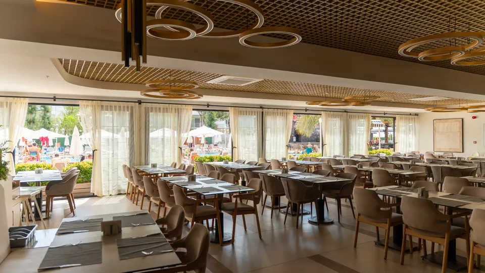 Restoran yemek alanında geniş pencere cephesine uygulanan tül perdeler