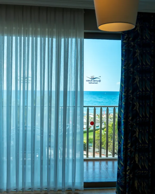 Otel odasında balkon kapısı boyunca tül ve desenli fon perde uygulaması